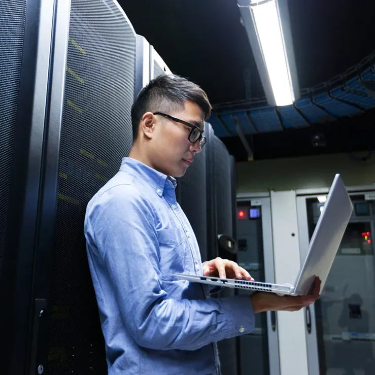 asian male providing server management solutions in data center